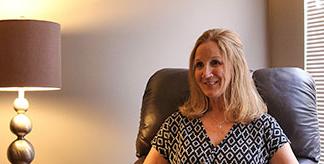 A counselor sitting in a chair, smiling